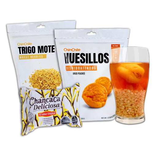 A bundle of Trigo Mote, Huesillos, and Chancaca next to a glass of Mote con Huesillo.