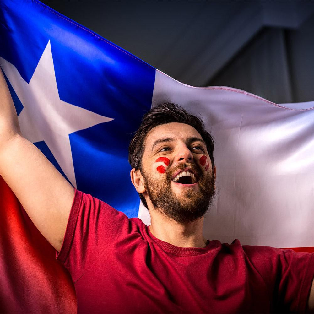 A man with sunglasses wearing a black t-shirt with a Chilean flag on it.