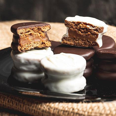 A plate of chocolate and white chocolate alfajores