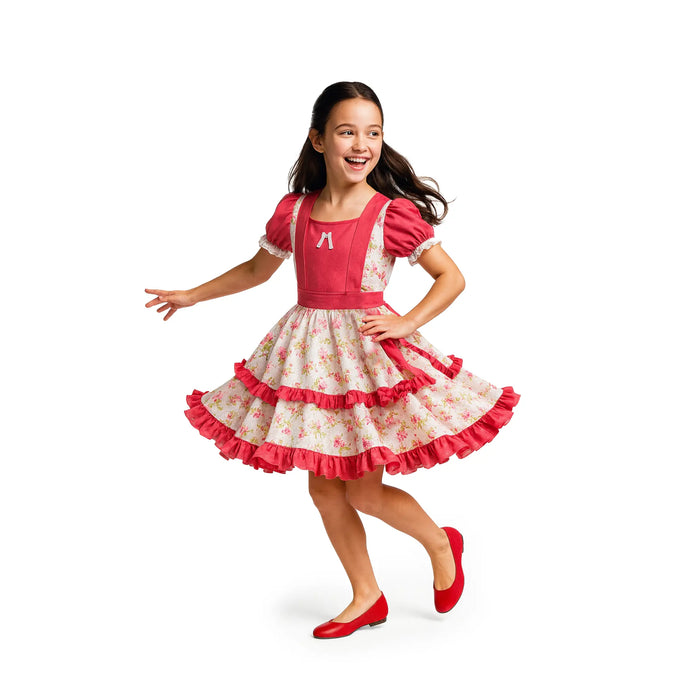 Girl running and smiling in Vestido Huasa Chinita children’s Chilean dress with pink bodice and light floral skirt.