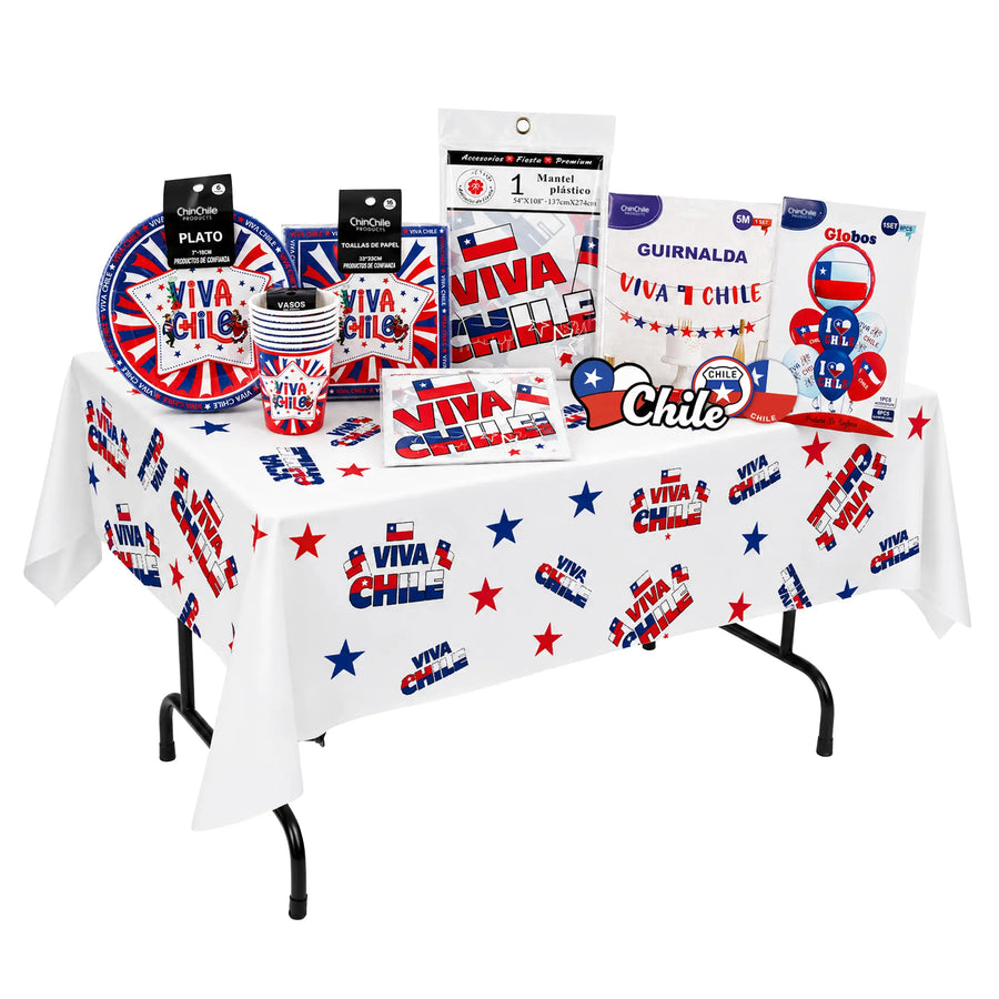 The Fiestas Patrias Bundle on a table draped in the white Viva Chile table cover: packaged paper plates, cups and napkins in the Viva Chile star design, a 5 m garland, an eight piece Chile balloon set, a folded Chilean flag, and Chile heart and badge stickers.