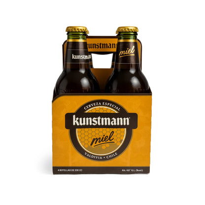 Botellas de cerveza Kunstmann miel en una caja de cartón de cuatro unidades sobre fondo blanco