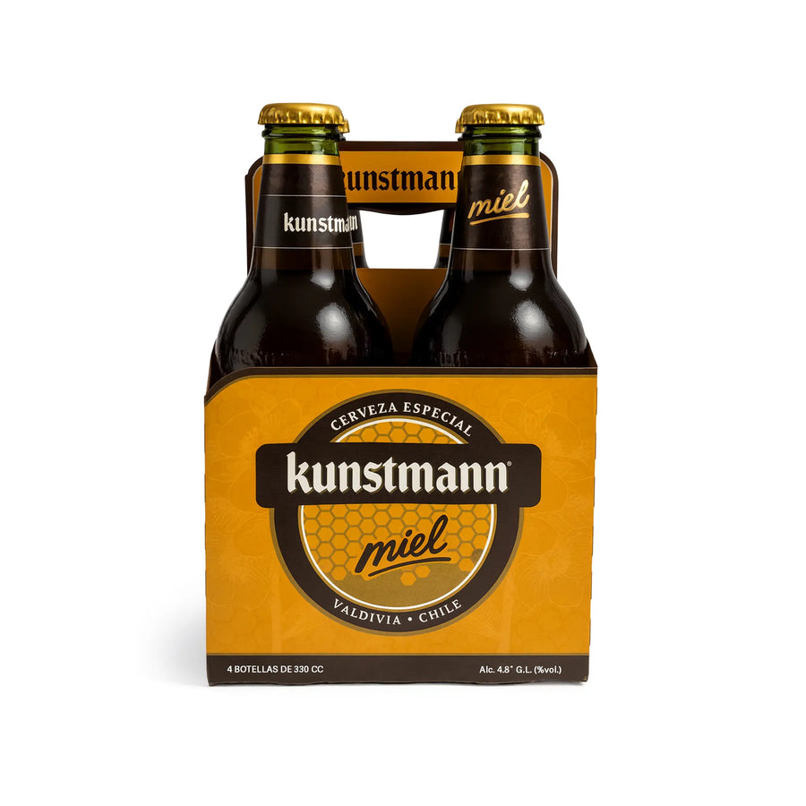 Botellas de cerveza Kunstmann miel en una caja de cartón de cuatro unidades sobre fondo blanco