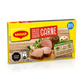 Una caja de «Maggi Caldo Deshidratado Sabor Carne» (caldo de setas y ternera) sobre un fondo blanco con un suave reflejo. El envase es principalmente de color amarillo, con texto en rojo y blanco, y muestra una imagen de carne cocida cortada en lonchas sobre una tabla de madera.