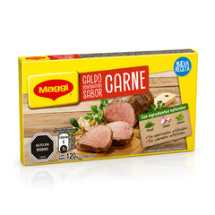 A box of Maggi Caldo Deshidratado Sabor Carne (mushroom and beef broth) on a white background with a soft reflection. The packaging is primarily yellow with red and white text, and features an image of sliced cooked meat on a wooden board.