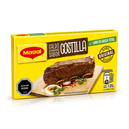 Una caja amarilla de «Maggi Caldo Deshidratado Sabor Costilla» sobre un fondo blanco con un suave reflejo. El envase muestra una fotografía de un filete de costilla cocinado sobre una tabla de madera, junto con el logotipo de Maggi y la información nutricional.