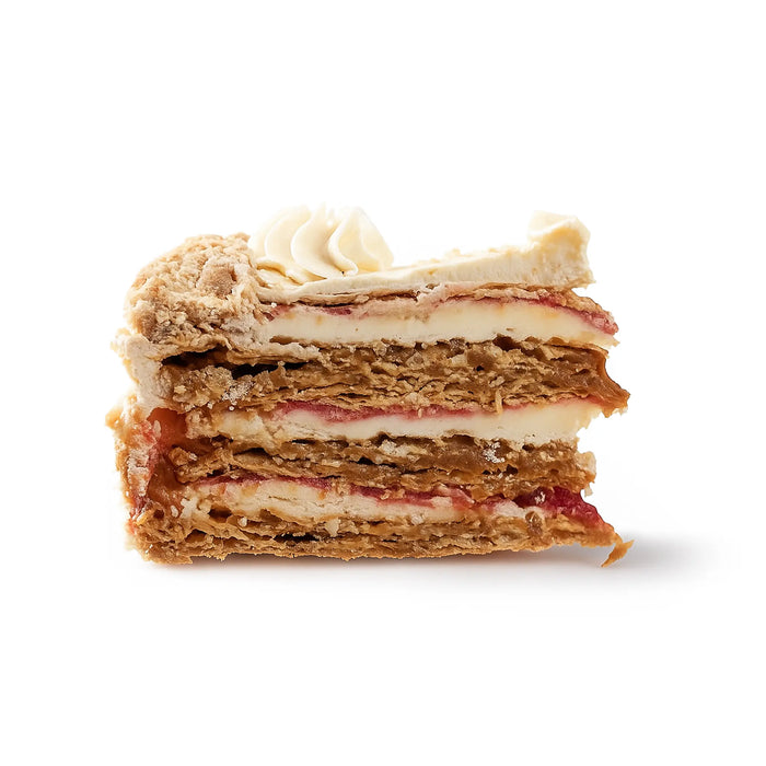 Layered dessert with meringue and fruit filling on a white background